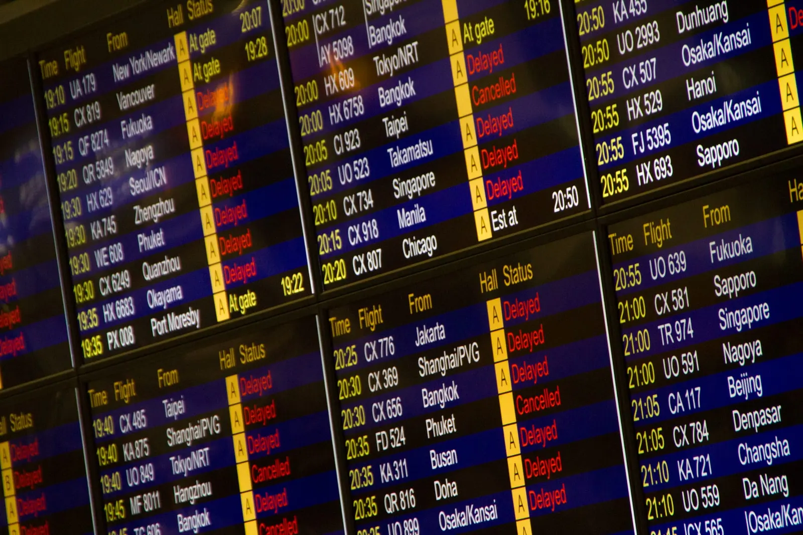 An airport departures board full of delayed flights